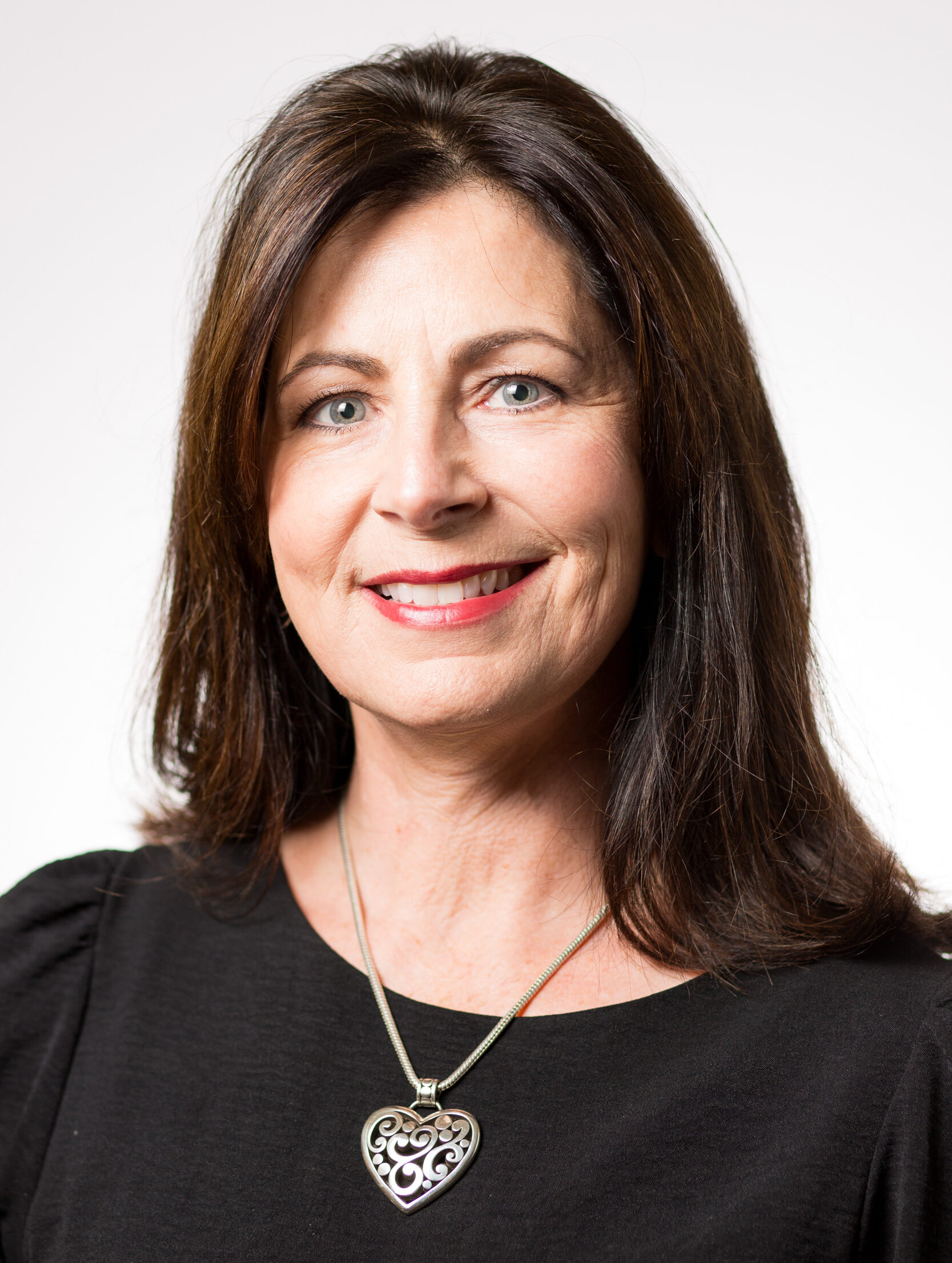 Lisa Cline in a black blouse with a heart necklace.
