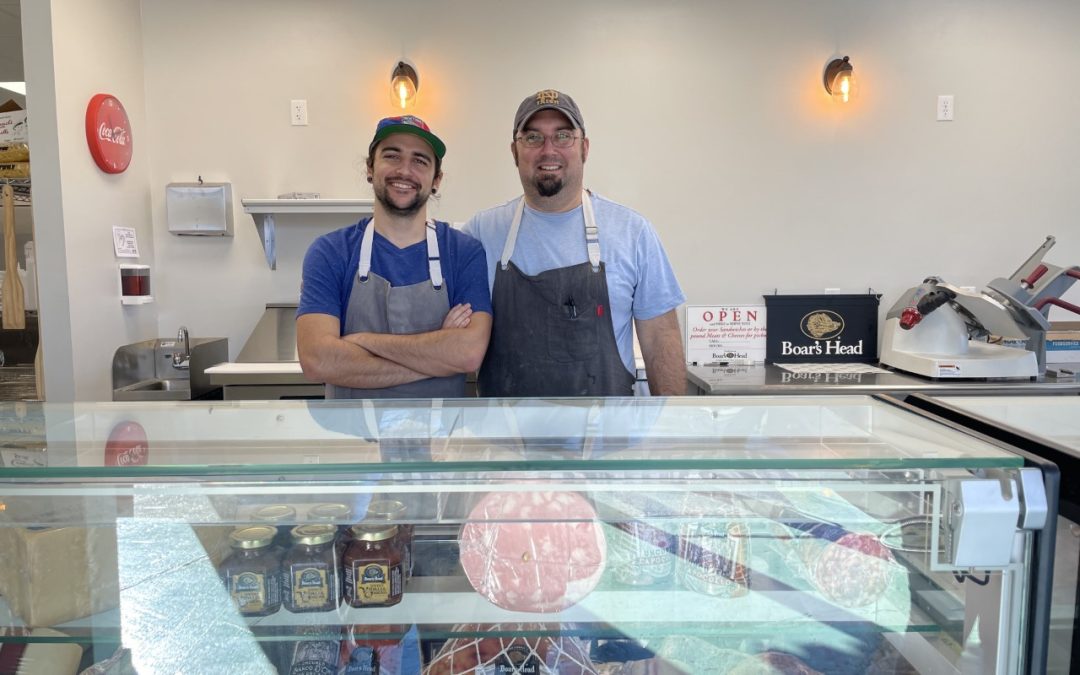 two men standing at a deli counter