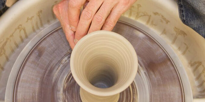 A student working with a pottery wheel